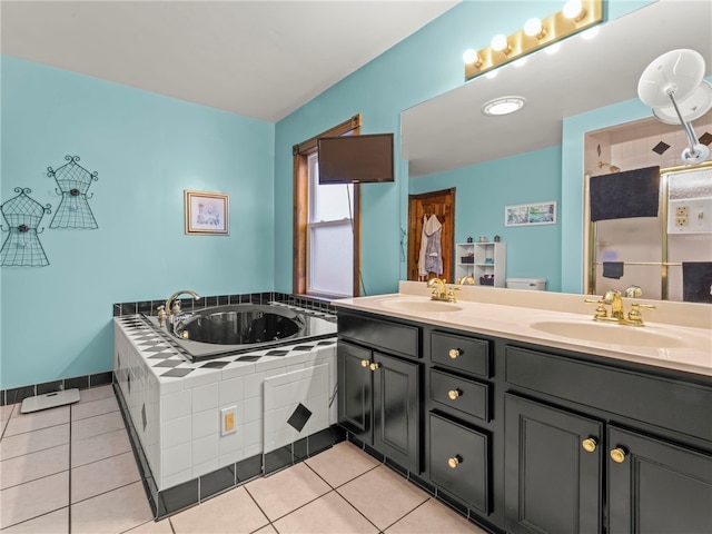 bathroom with tile patterned floors, toilet, tiled bath, and vanity