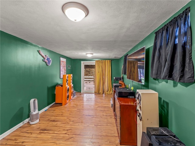 miscellaneous room featuring wood-type flooring and a textured ceiling