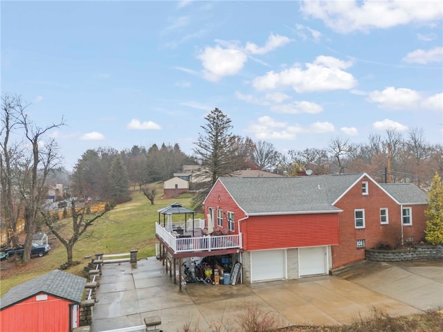 exterior space featuring a wooden deck, a garage, and a gazebo