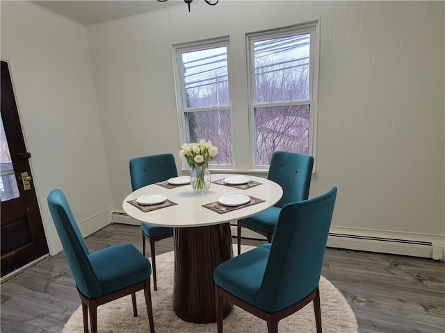 dining room featuring crown molding, a baseboard radiator, and hardwood / wood-style floors
