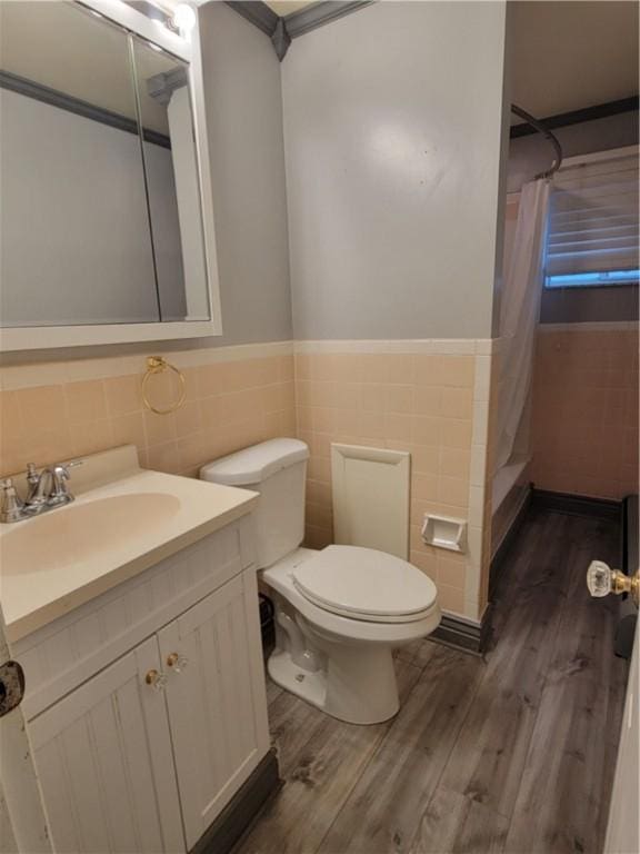 bathroom with tile walls, hardwood / wood-style floors, vanity, and toilet
