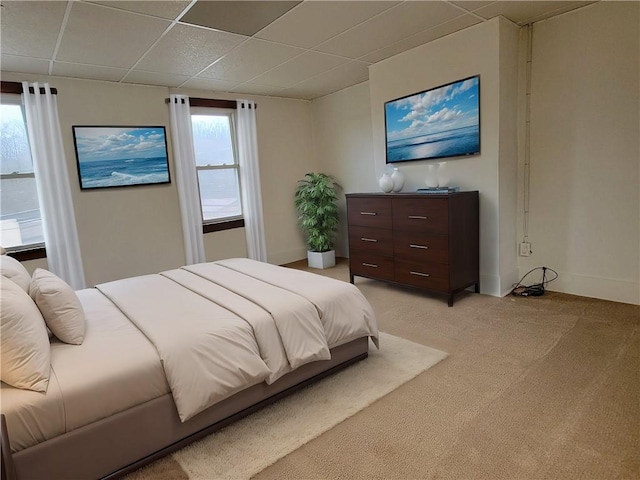carpeted bedroom featuring a drop ceiling