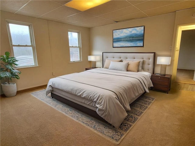 carpeted bedroom featuring a drop ceiling