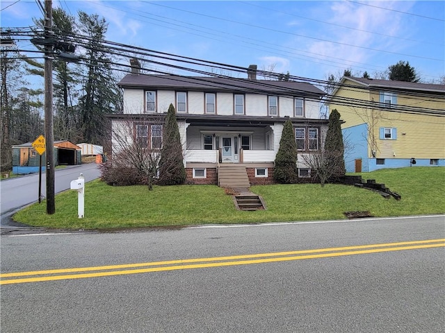 view of front facade with a front yard and covered porch