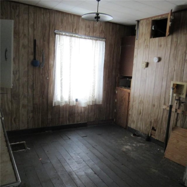 empty room with dark hardwood / wood-style floors and wood walls