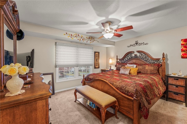 bedroom featuring light carpet, a textured ceiling, and ceiling fan