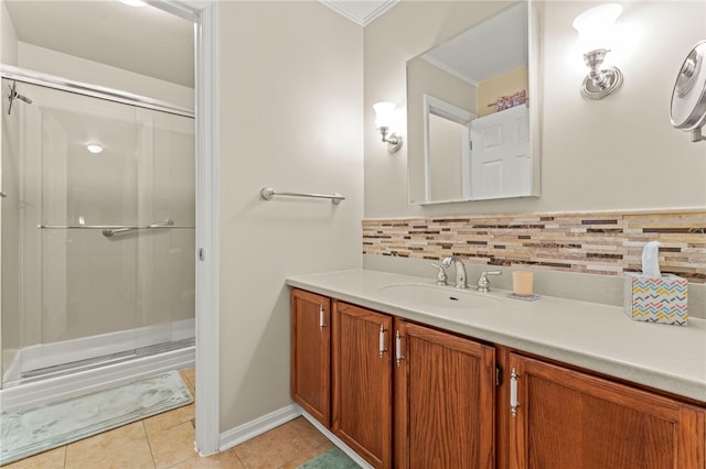 bathroom with tasteful backsplash, ornamental molding, vanity, a shower with door, and tile patterned flooring