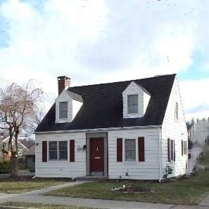 cape cod house with a front yard