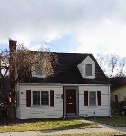 new england style home featuring a front lawn