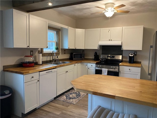 kitchen featuring stainless steel appliances, butcher block countertops, and white cabinets