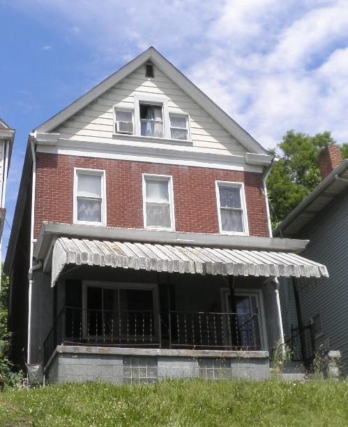 back of property featuring covered porch