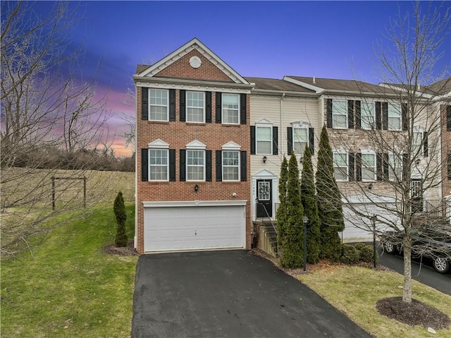 view of front of home with a garage and a lawn