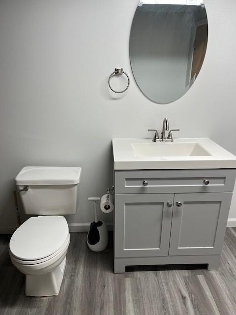 bathroom featuring hardwood / wood-style flooring, vanity, and toilet