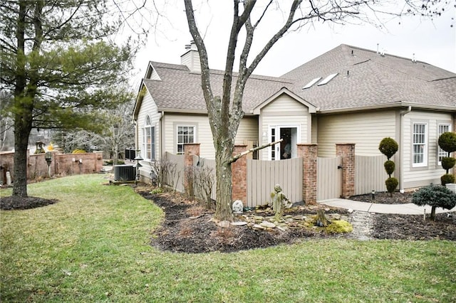 view of front facade with cooling unit and a front yard