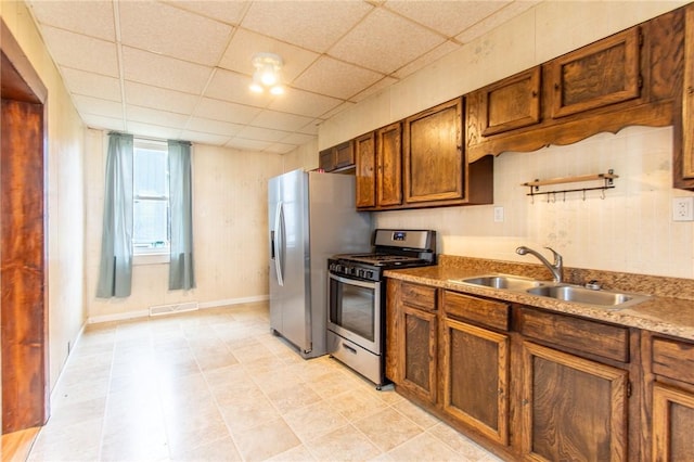 kitchen with sink, a paneled ceiling, and appliances with stainless steel finishes