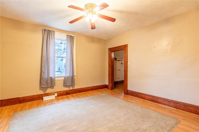 spare room with hardwood / wood-style flooring and ceiling fan