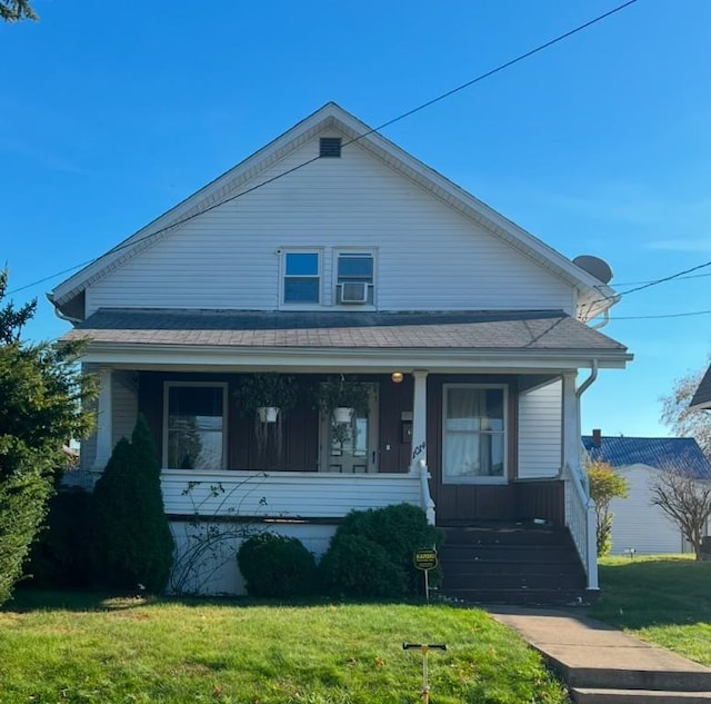 bungalow-style house featuring covered porch and a front lawn