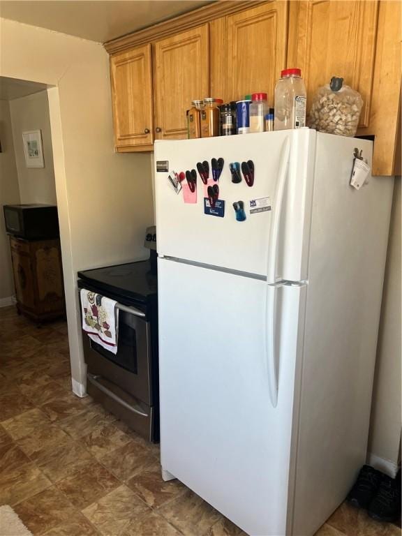 kitchen with stainless steel range with electric stovetop and white refrigerator