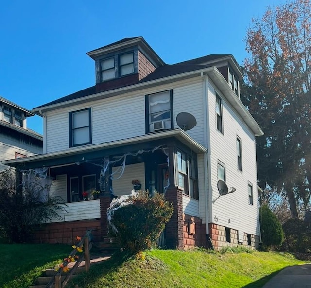 view of front of home with a porch and a front lawn