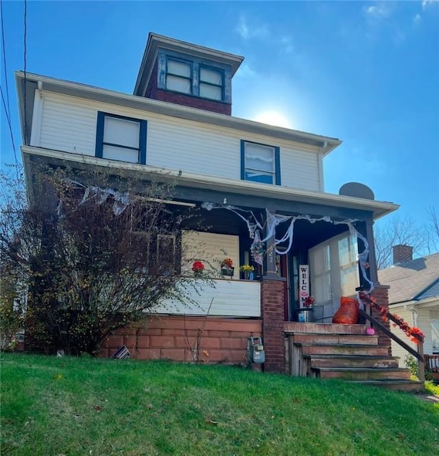 view of front facade with covered porch and a front lawn