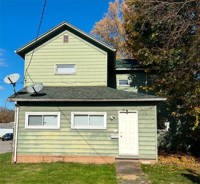 rear view of house featuring a yard