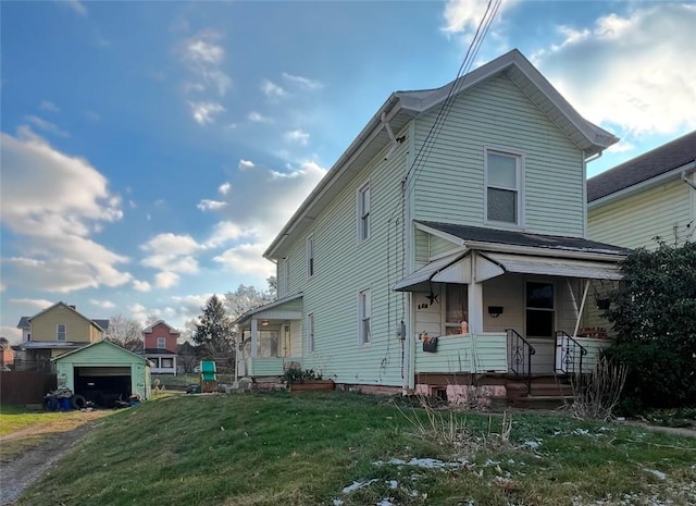 view of property featuring a garage, a front yard, and a porch