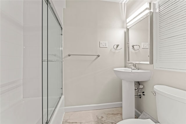 bathroom featuring toilet and combined bath / shower with glass door