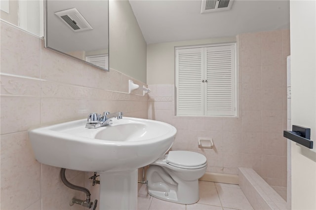 bathroom featuring tile walls, a shower, tile patterned floors, and toilet