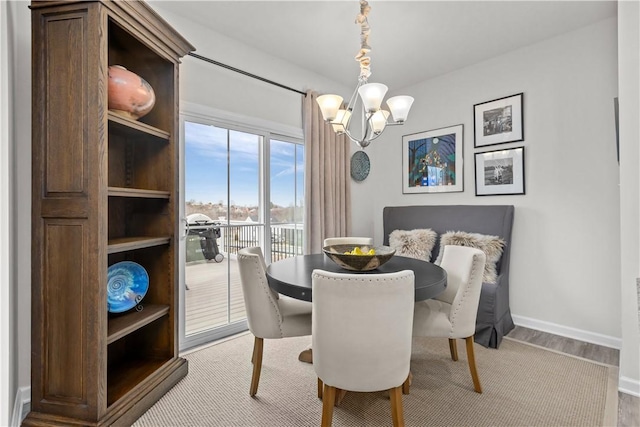 dining room with light hardwood / wood-style flooring and a notable chandelier