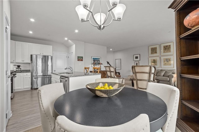 dining space featuring sink, a notable chandelier, and hardwood / wood-style flooring