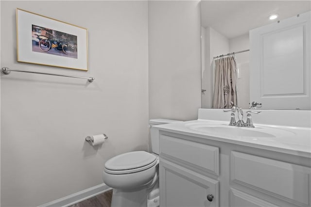 bathroom featuring vanity, wood-type flooring, toilet, and walk in shower