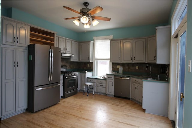 kitchen with appliances with stainless steel finishes, sink, and gray cabinetry