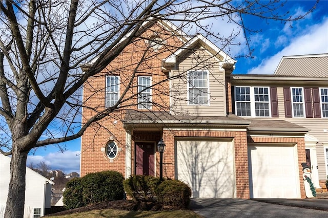 view of front facade with driveway, an attached garage, and brick siding