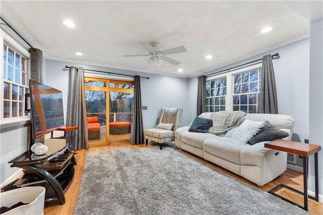 living room featuring ornamental molding, ceiling fan, and light hardwood / wood-style flooring