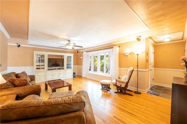 living room featuring hardwood / wood-style flooring, ornamental molding, and ceiling fan