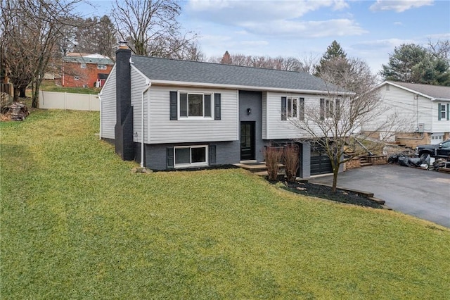 split foyer home with a garage and a front lawn