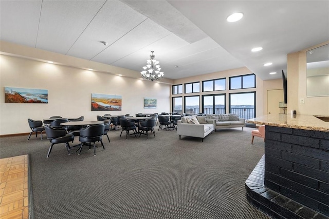 carpeted living room featuring baseboards, recessed lighting, and a chandelier