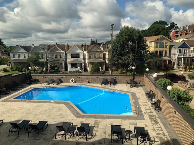 community pool featuring a residential view and a patio area