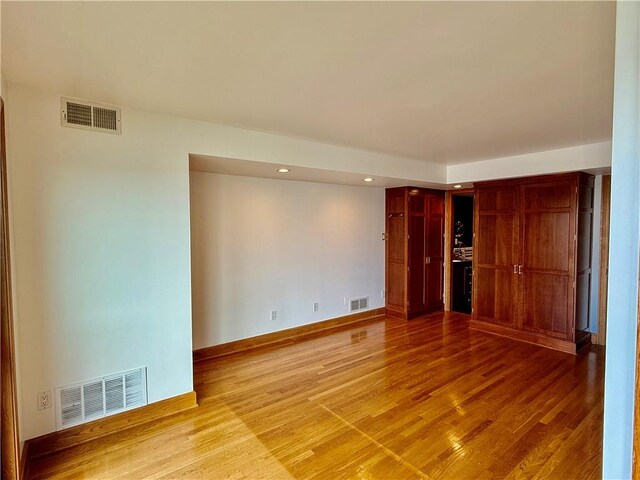 empty room featuring wood finished floors, recessed lighting, and baseboards