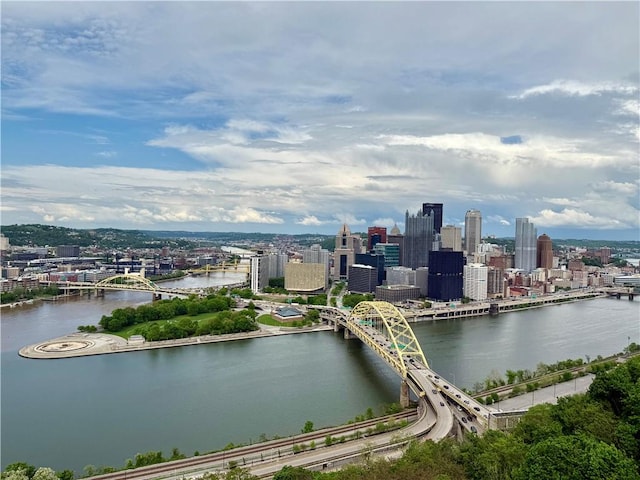 drone / aerial view of a notable bridge, a view of skyline, and a nearby body of water