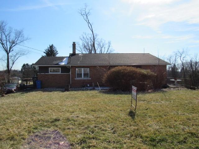 back of house featuring a lawn