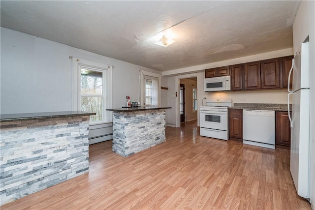 kitchen featuring a baseboard radiator, light wood-type flooring, and white appliances