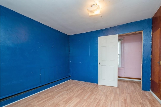 empty room featuring light hardwood / wood-style floors and baseboard heating