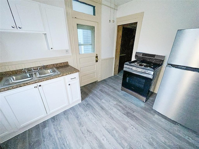 kitchen featuring white cabinetry, stainless steel appliances, and light wood-type flooring