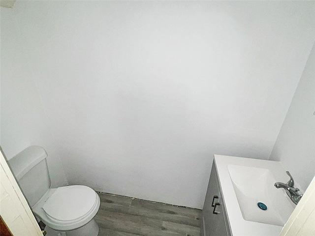 bathroom with vanity, hardwood / wood-style flooring, and toilet