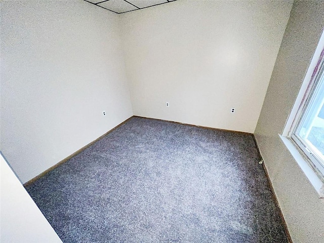 unfurnished room with dark colored carpet