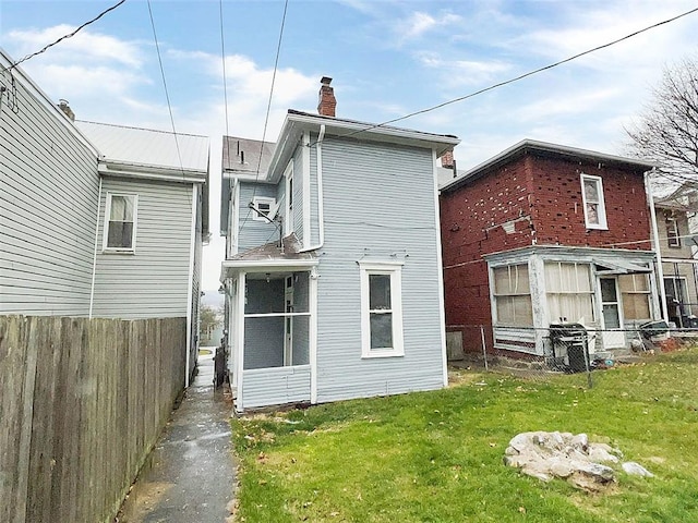 rear view of house featuring a yard