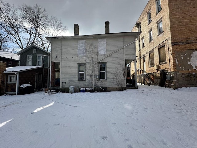 view of snow covered back of property