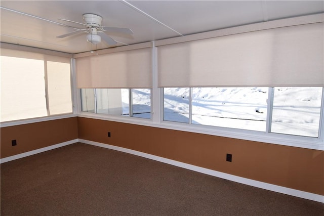 unfurnished sunroom featuring ceiling fan