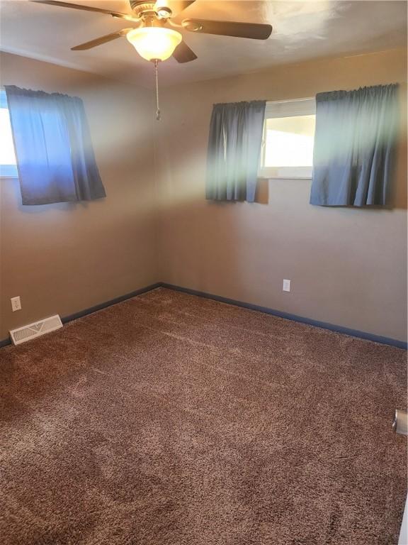 spare room with ceiling fan and carpet